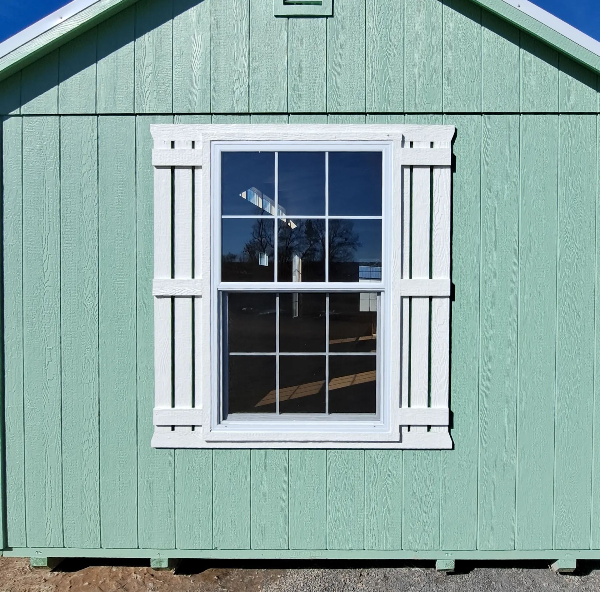 Green building with white window trim