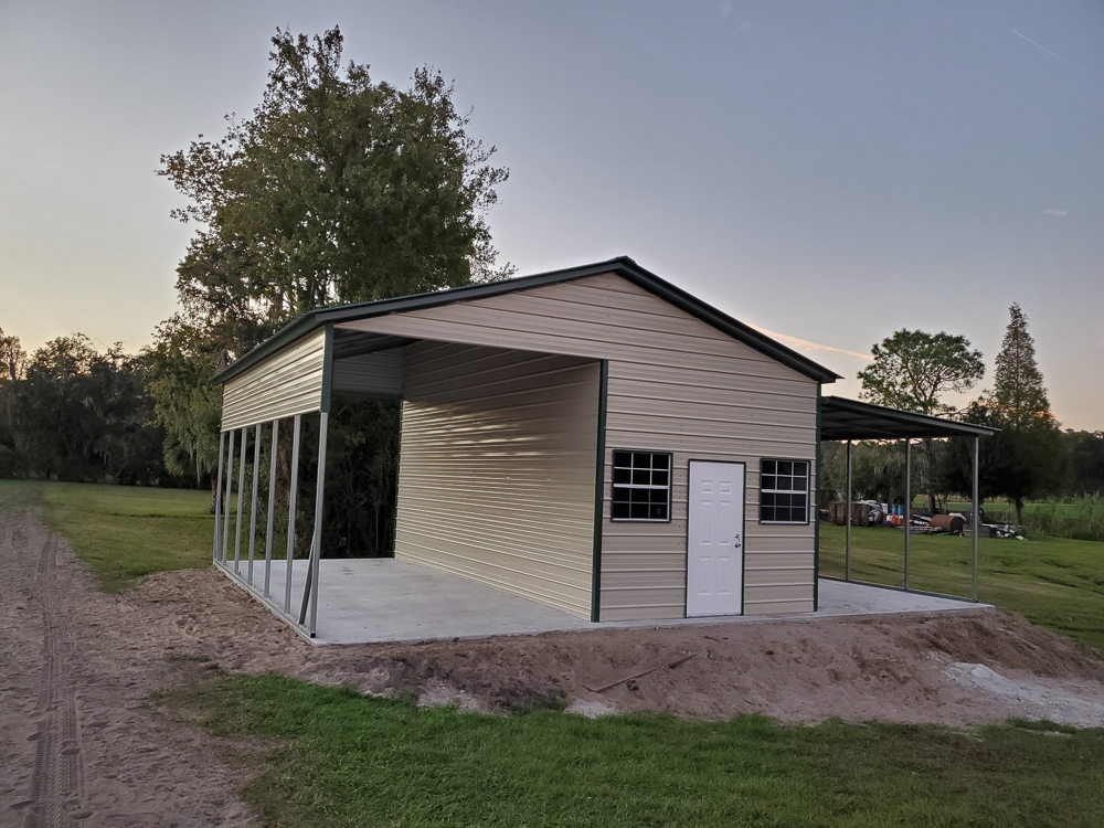 Tan metal building with carport extensions, dark trim, a white entry door, and grid windows on a concrete slab in Crystal River, FL.