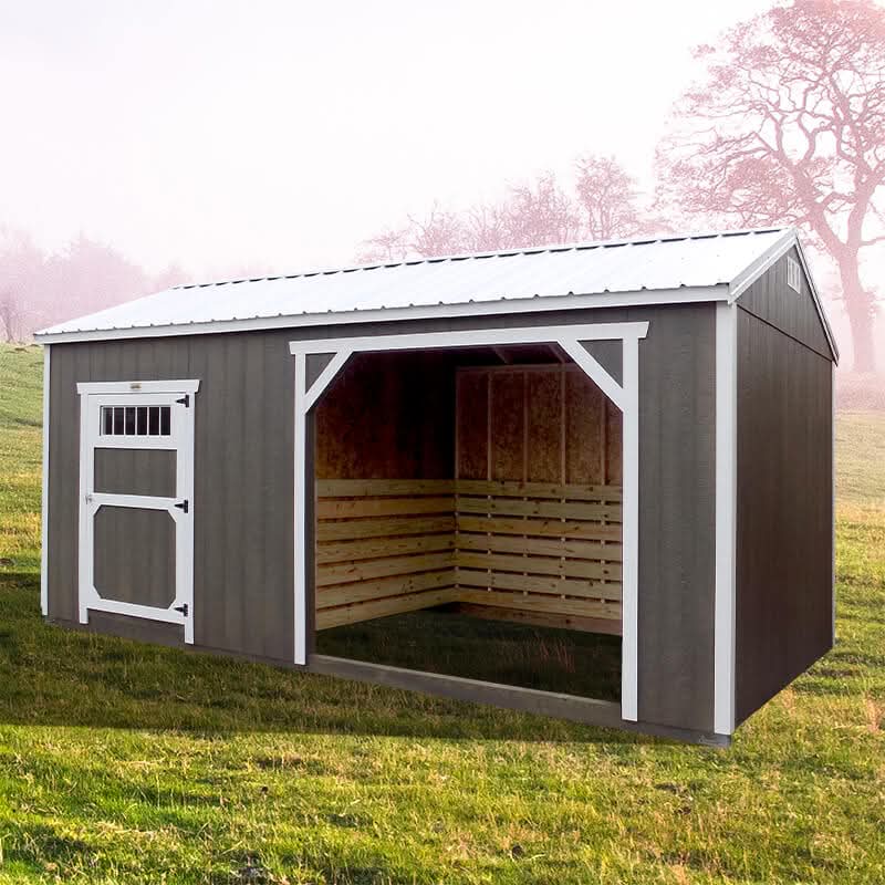 A dark gray wooden loafing shed featuring a white-trimmed entry door on the left and an open livestock shelter bay on the right in Dallas, TX.