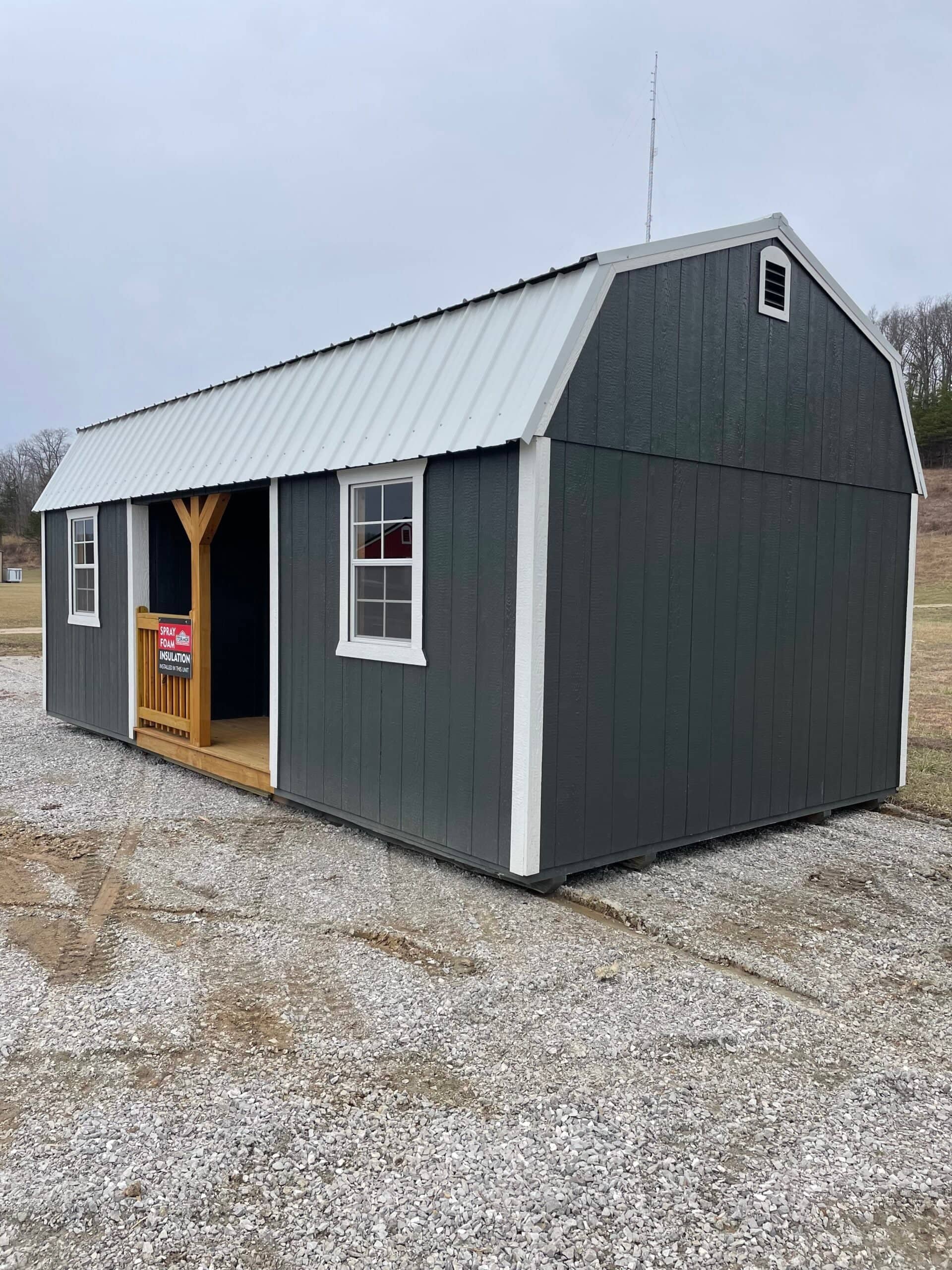 Gray barn-style shed with porch