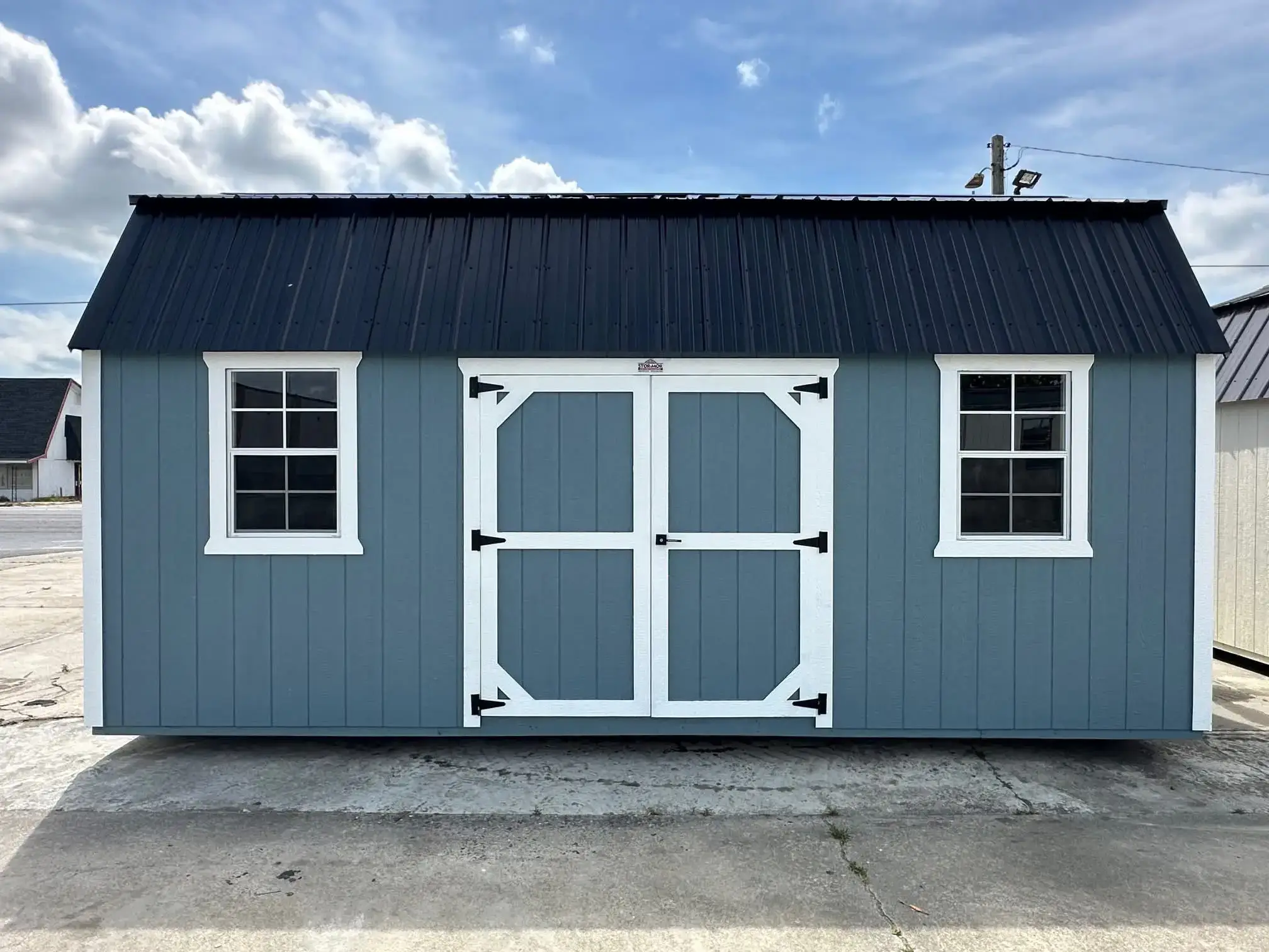 Blue shed with white doors and windows