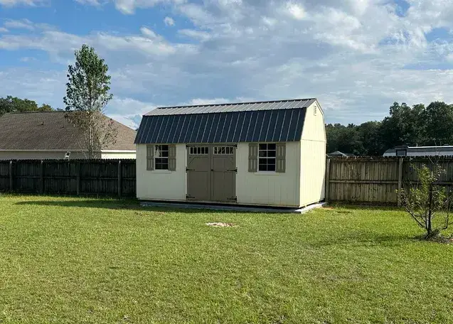 White shed in grassy backyard