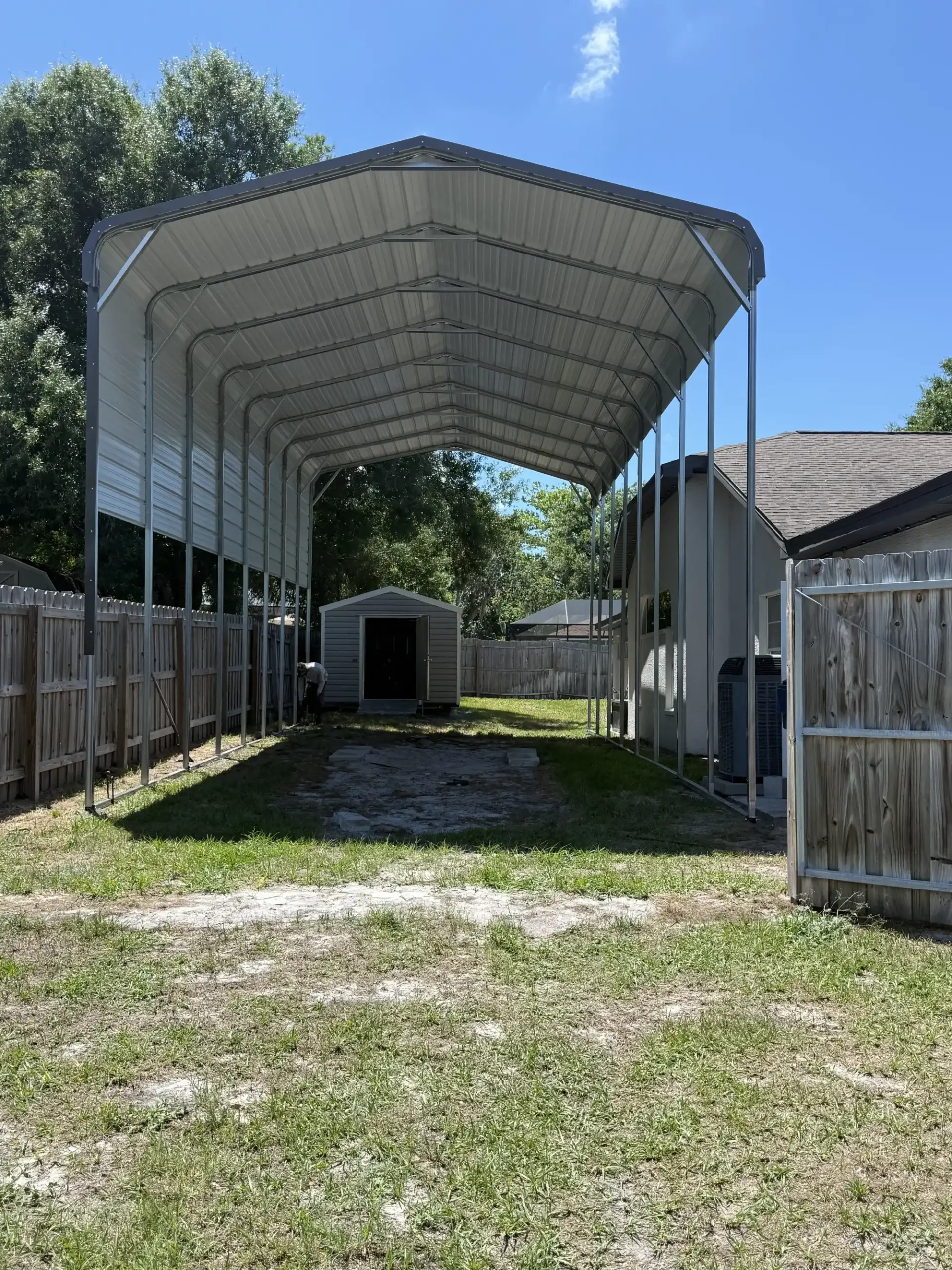 Large metal carport in grassy area