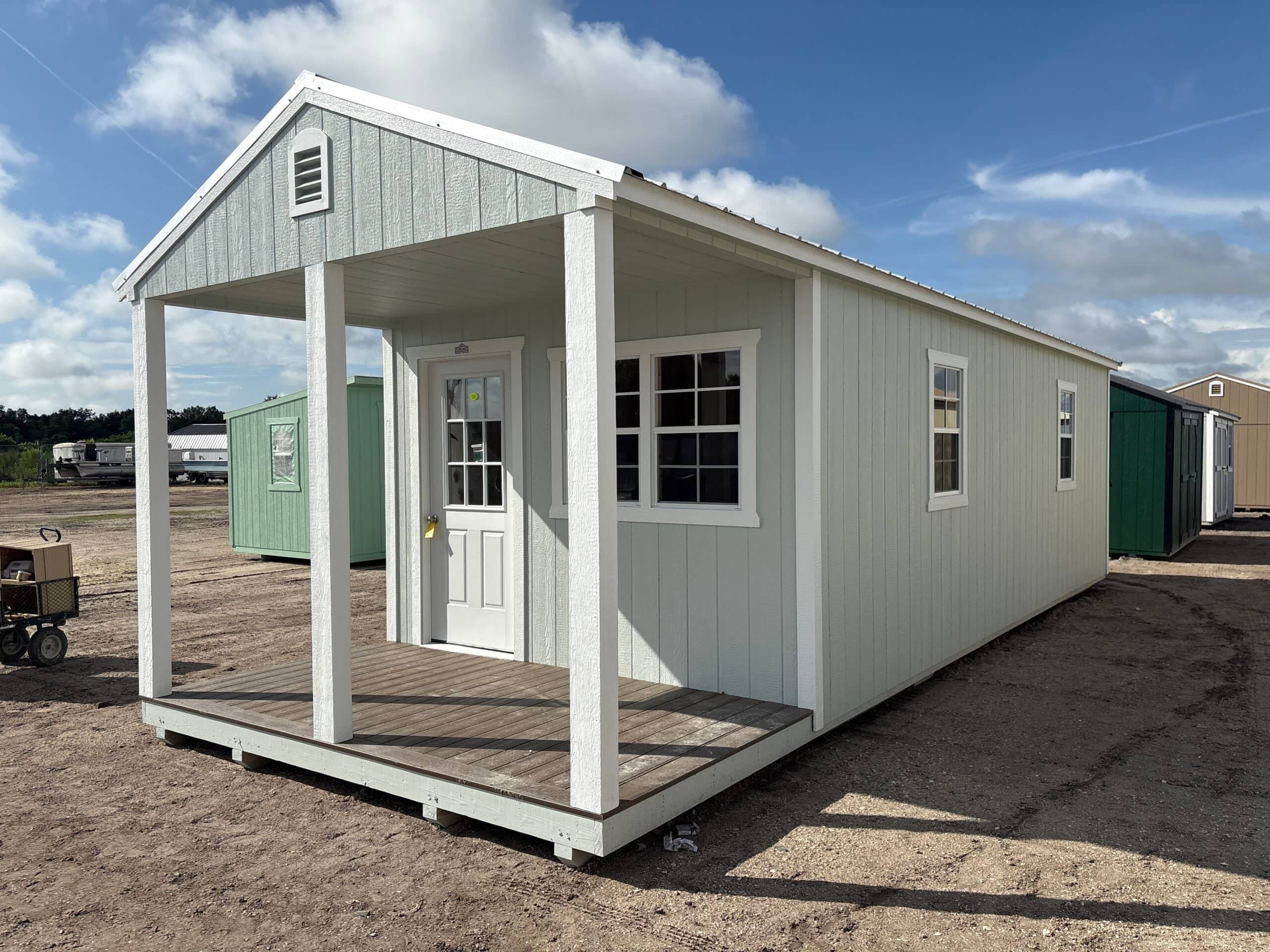 Light-colored cabin with porch entrance.