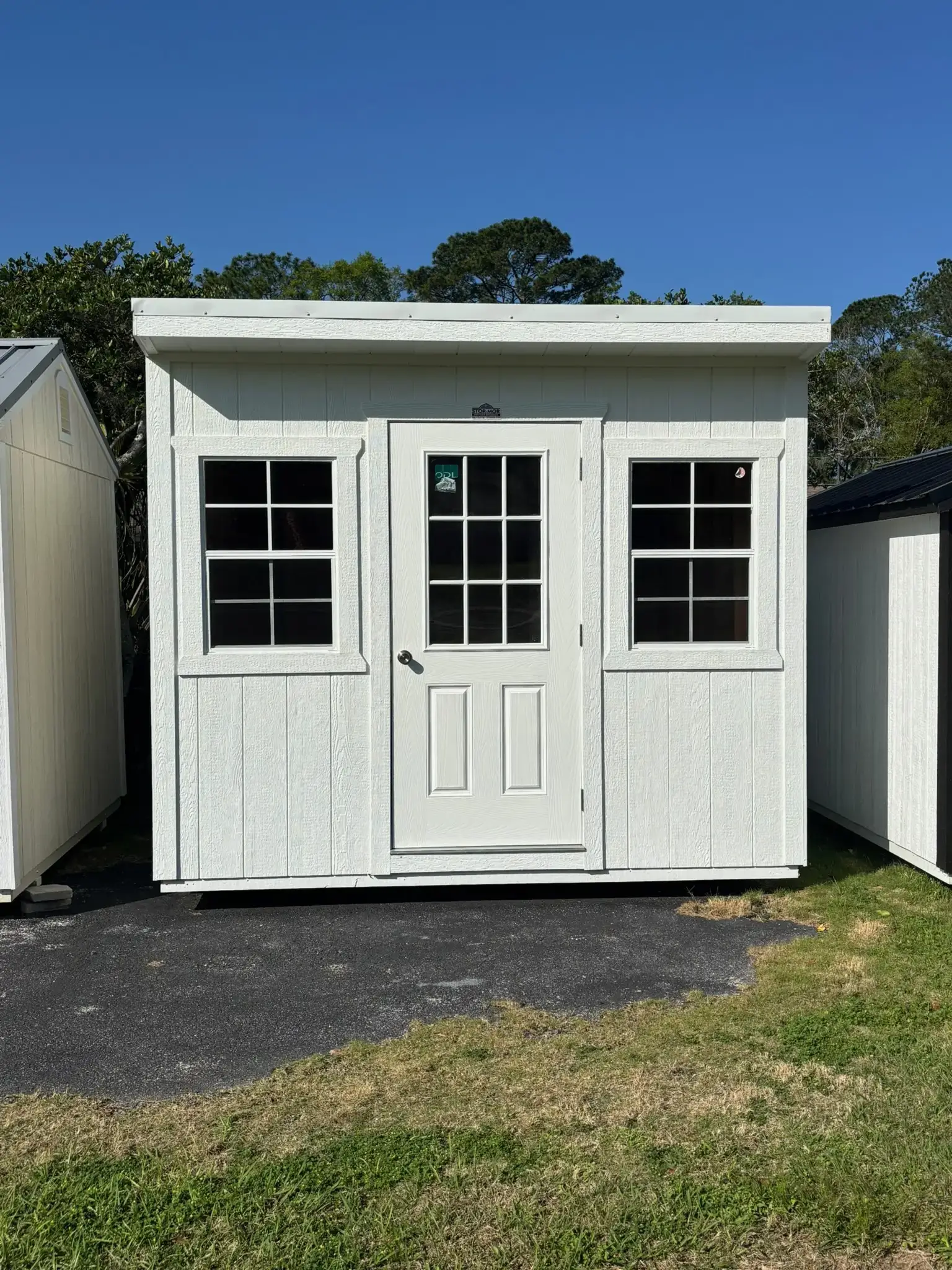 White wooden shed with windows and door